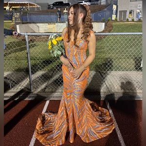 Beautiful orange sequin evening gown with a long train skirt